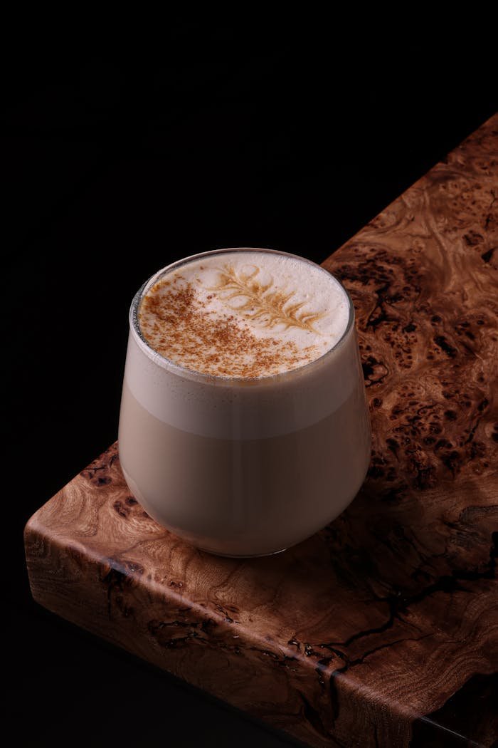Elegant cappuccino with latte art on a rustic wooden table, inviting warmth.